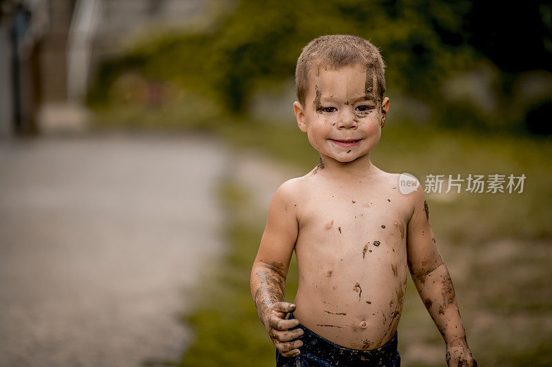 小男孩在泥里玩。