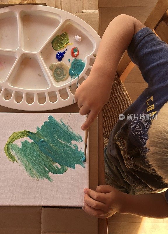 孩子用丙烯酸颜料在画布上作画