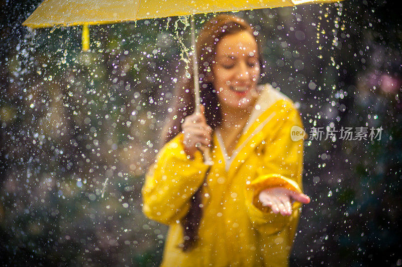 秋雨中带着透明塑料伞的快乐女人