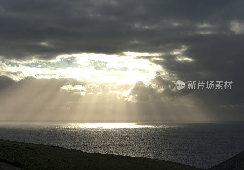 英国多塞特的侏罗纪海岸，阴郁天空中的阳光