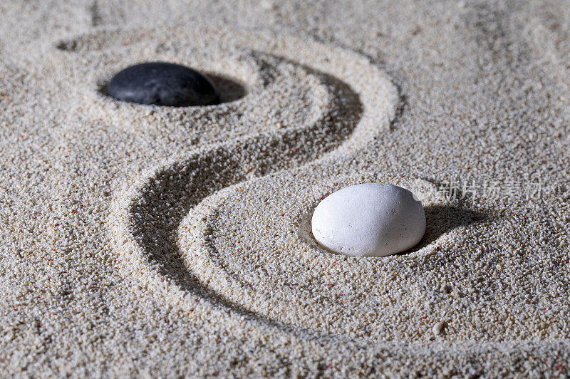 ,沙子上面放着黑白两块石头拼成的太极图案