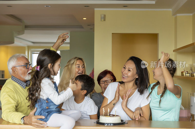 一个快乐的大家庭正在庆祝一个漂亮女人的生日。