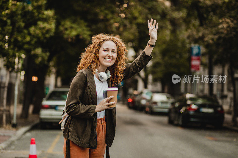 一位红头发的年轻女子在叫出租车