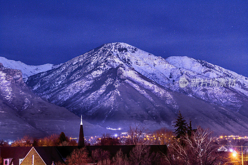 白雪皑皑的瓦萨奇山高耸于普洛伏市中心，映衬着湛蓝的夜空