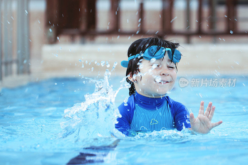快乐的小男孩在游泳池里享受夏日时光