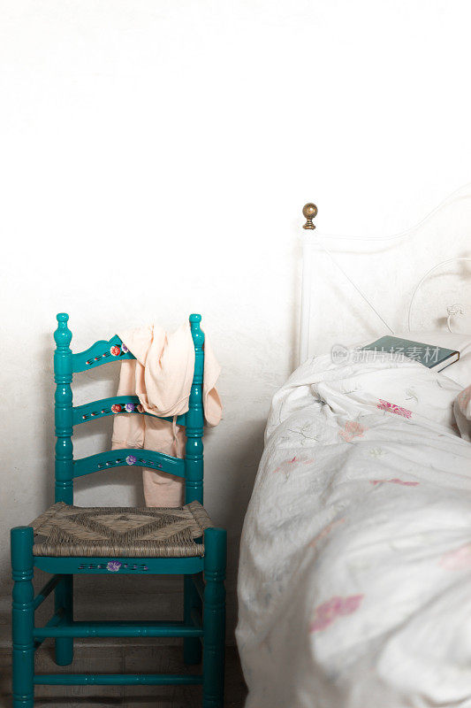 乡村卧室，蓝色的椅子，未整理的床
