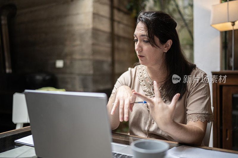 一个女人在家里用笔记本电脑进行虚拟商务会议