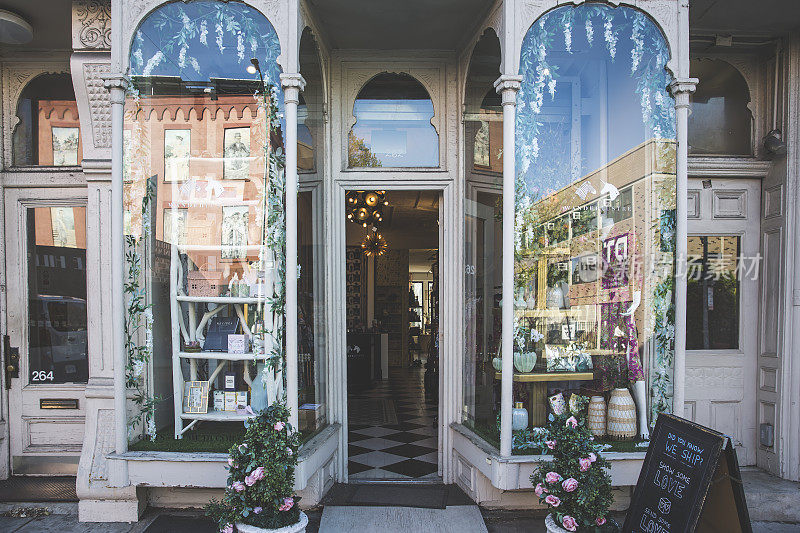 玫瑰盆栽和装饰展示在一个商店的入口。古董店的复古外观