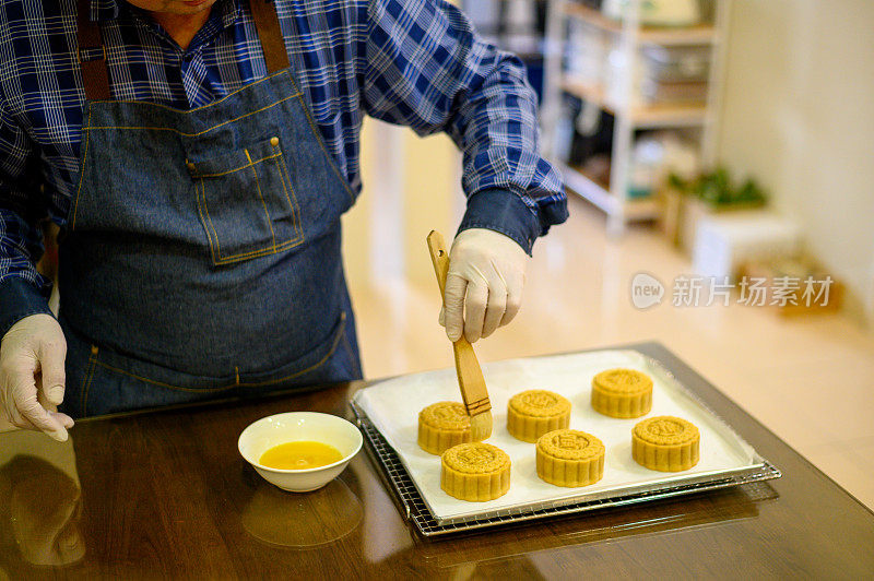 面包师在烤盘上用鸡蛋面团画自制月饼