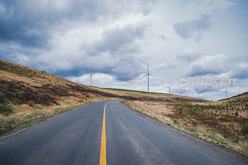 在风力发电机下的草原山间公路