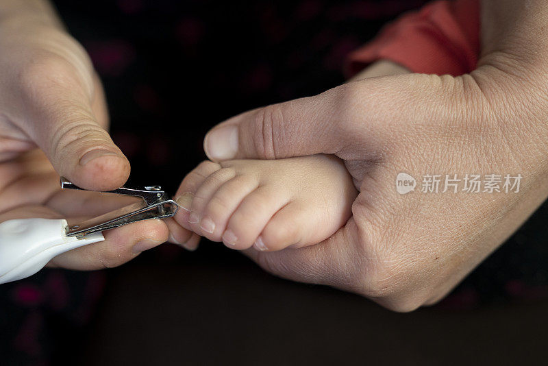 妈妈用指甲钳给女儿剪脚趾甲