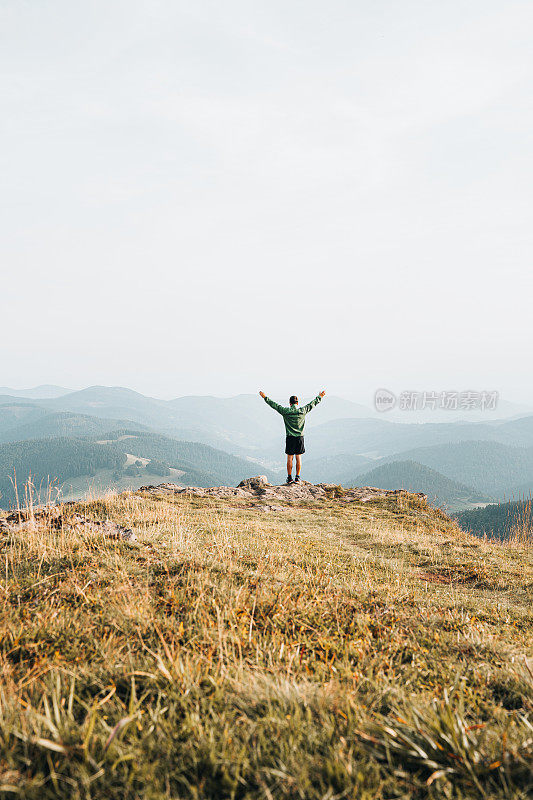 徒步旅行者在长满草的山脊上放松的观点