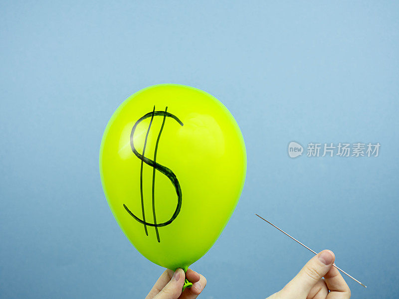 绿色的球，上面有美元的符号，手上有一根针，背景是蓝色的。货币概念，货币汇率
