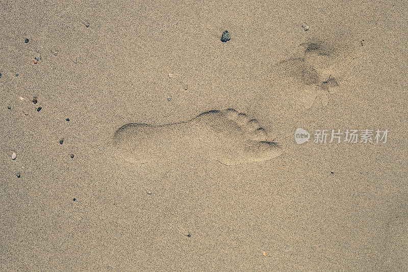 沙滩上的沙滩上有一个人留下的脚印，俯视图