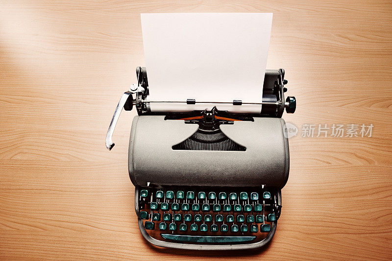 20世纪中期的古董打字机，上面有一页空白的纸，可以用来写小说