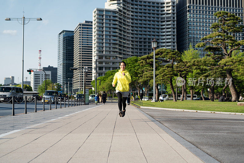 年轻女子在城市街道上奔跑