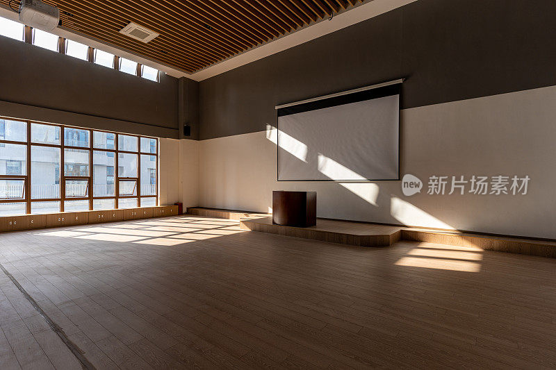 阳光透过窗户照在空荡荡的多媒体教室的木纹地板上