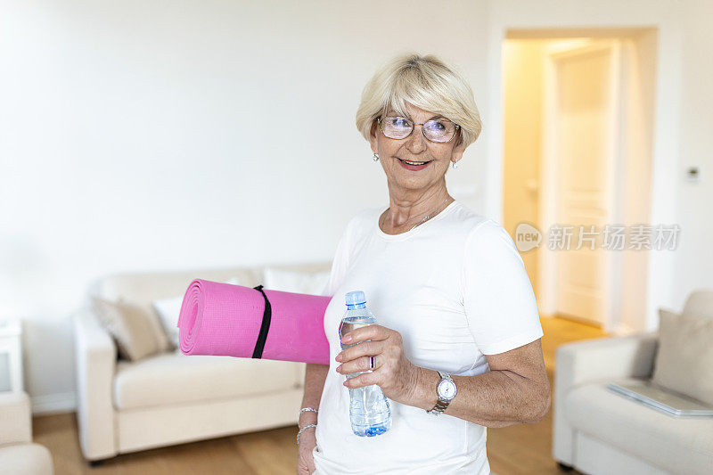 成熟的女性准备去锻炼。老妇人准备好锻炼了。点心后培训。运动的老妇人正在喝水