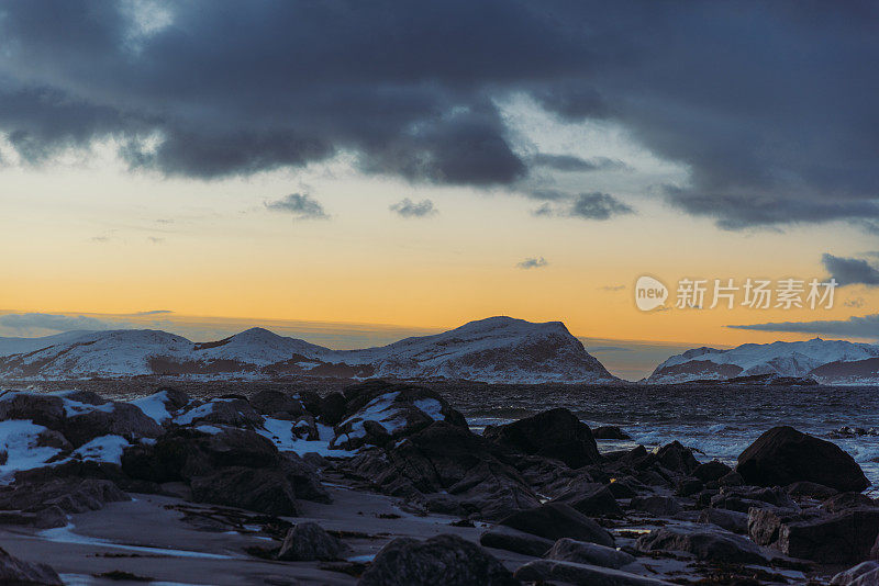 在挪威明亮的日落期间，冬季海滩的风景