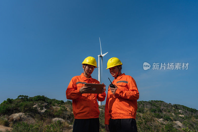 电力工程师使用平板记录风电场运行情况