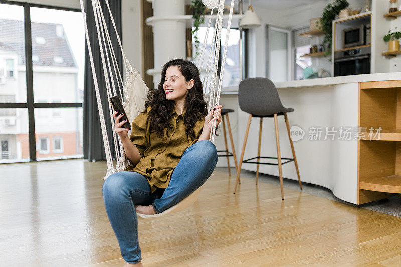 女人在家里玩手机