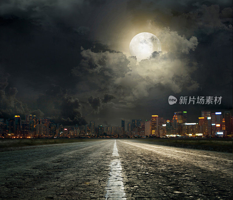 在多云的夜晚，月光照耀下的城市道路的街景