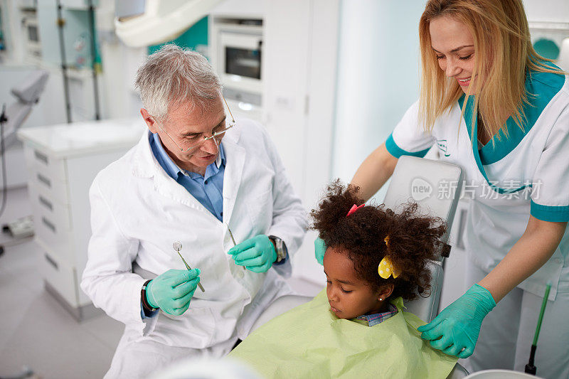 牙医和他的助手安慰小女孩