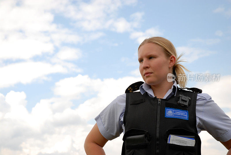 一个穿着警察背心的女人站在天空前
