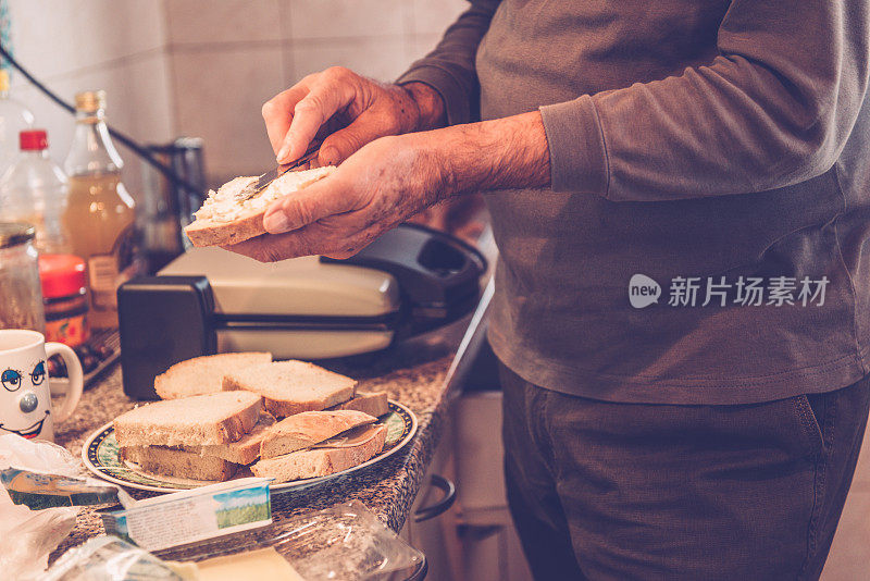 特写的高级男子在准备早餐，布拉克，克罗地亚