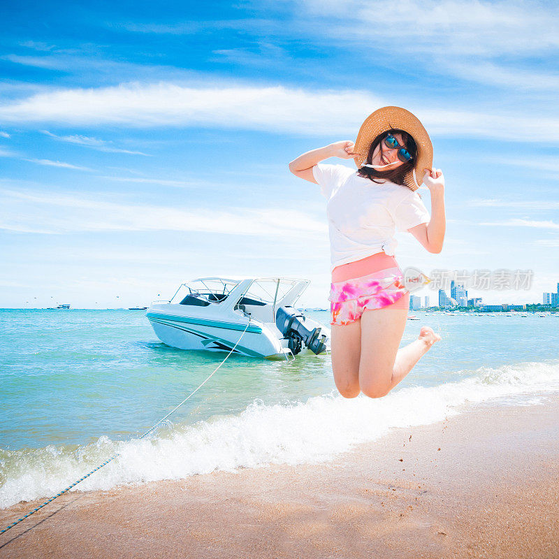 美丽的年轻女子在海滩上玩