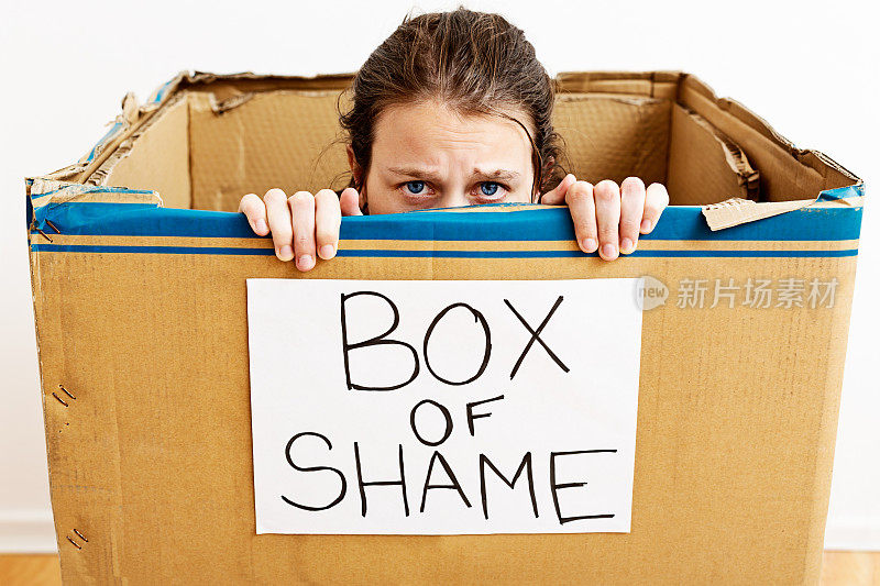 羞愧的年轻女子被关在羞愧之盒里——真丢脸!