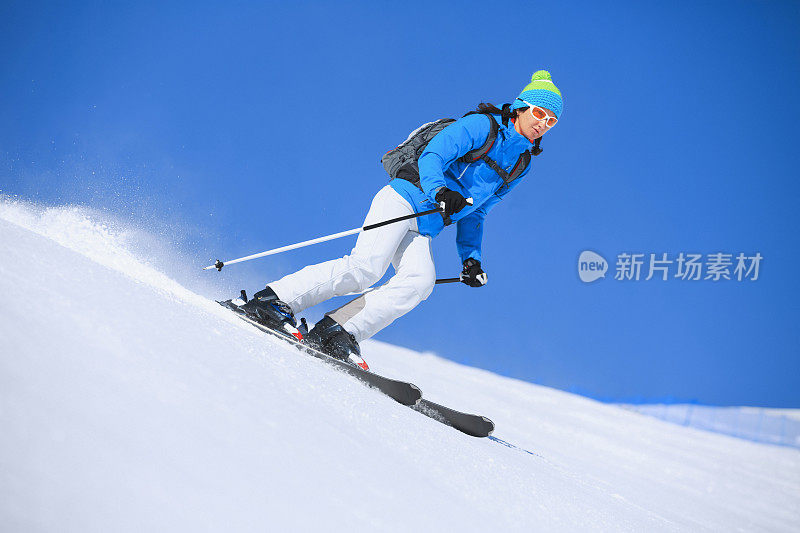 冬季运动女子滑雪者在阳光明媚的滑雪胜地滑雪