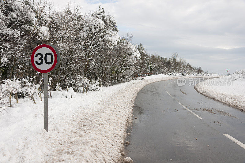 在积雪的德文郡山顶的道路上有30英里每小时的速度标志