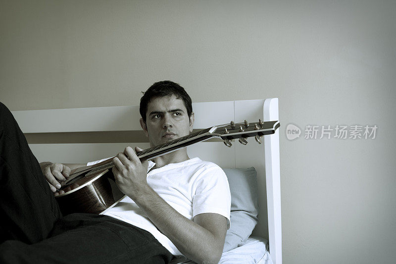 男人在卧室里弹吉他