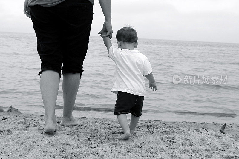 妈妈和宝宝在海滩上散步