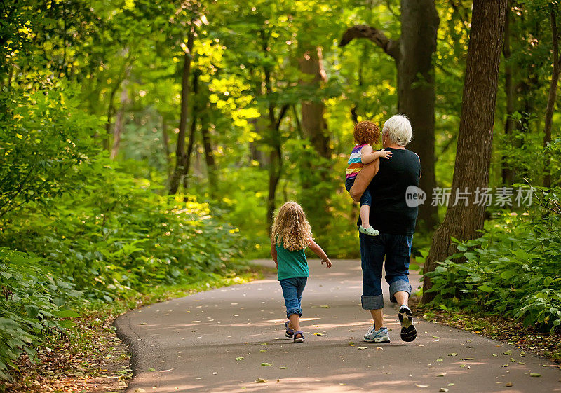 奶奶和孙女们在公园小径上散步