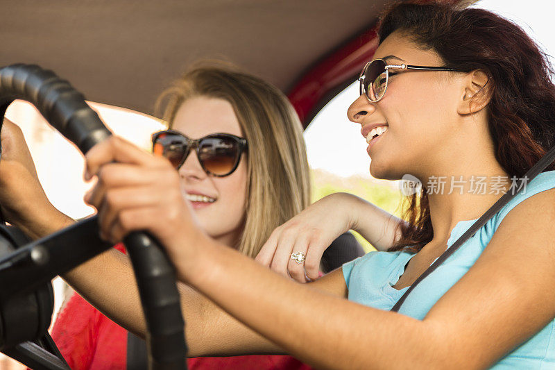 多民族少女进行夏季公路旅行。驾驶车辆。