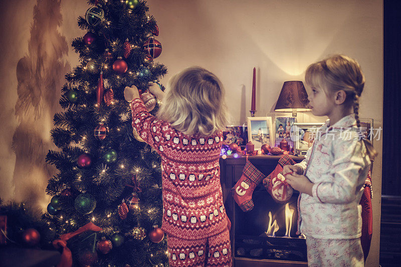 可爱的女孩装饰圣诞树