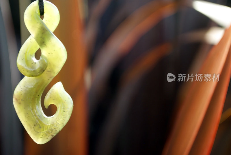 绿石(Pounamu)吊坠与Harakeke在软焦点