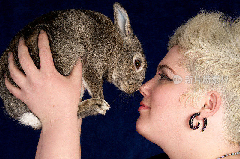 兔子和年轻女子在摸鼻子。