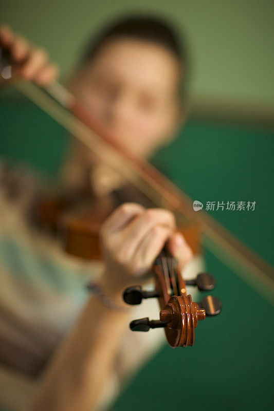 近距离柔和的聚焦:少女在拉小提琴