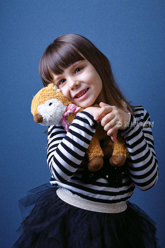 漂亮的女孩抱着玩具熊