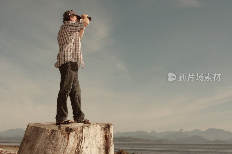 一个站在树桩上用望远镜看的人