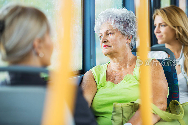 坐公交车上下班的老年妇女。