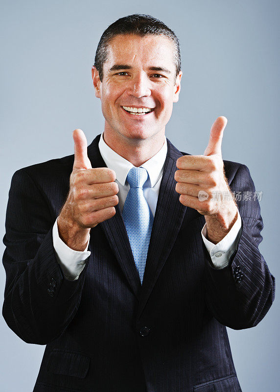 热情的商人微笑着竖起双大拇指表示赞同