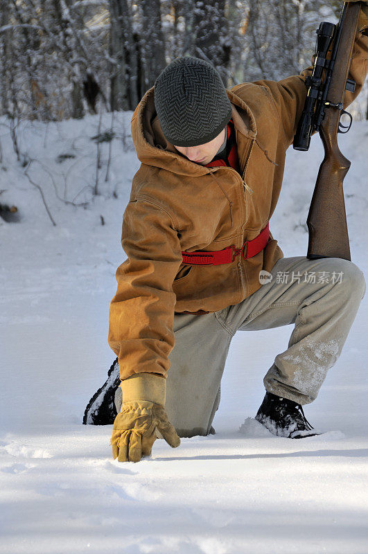 猎人在雪地里检查足迹