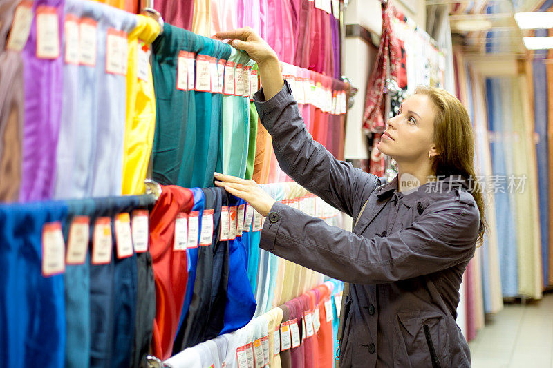 女人在商店里买布料