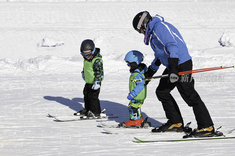 滑雪教练和两个小男孩