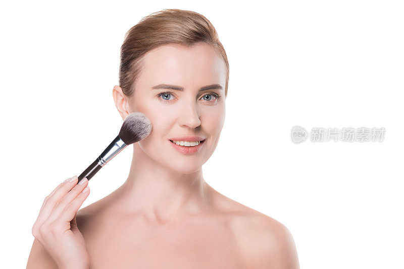 女人用清洁的皮肤使用化妆品粉隔离在白色