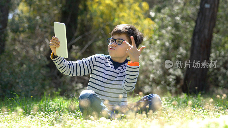 快乐的孩子在森林中使用数字平板电脑